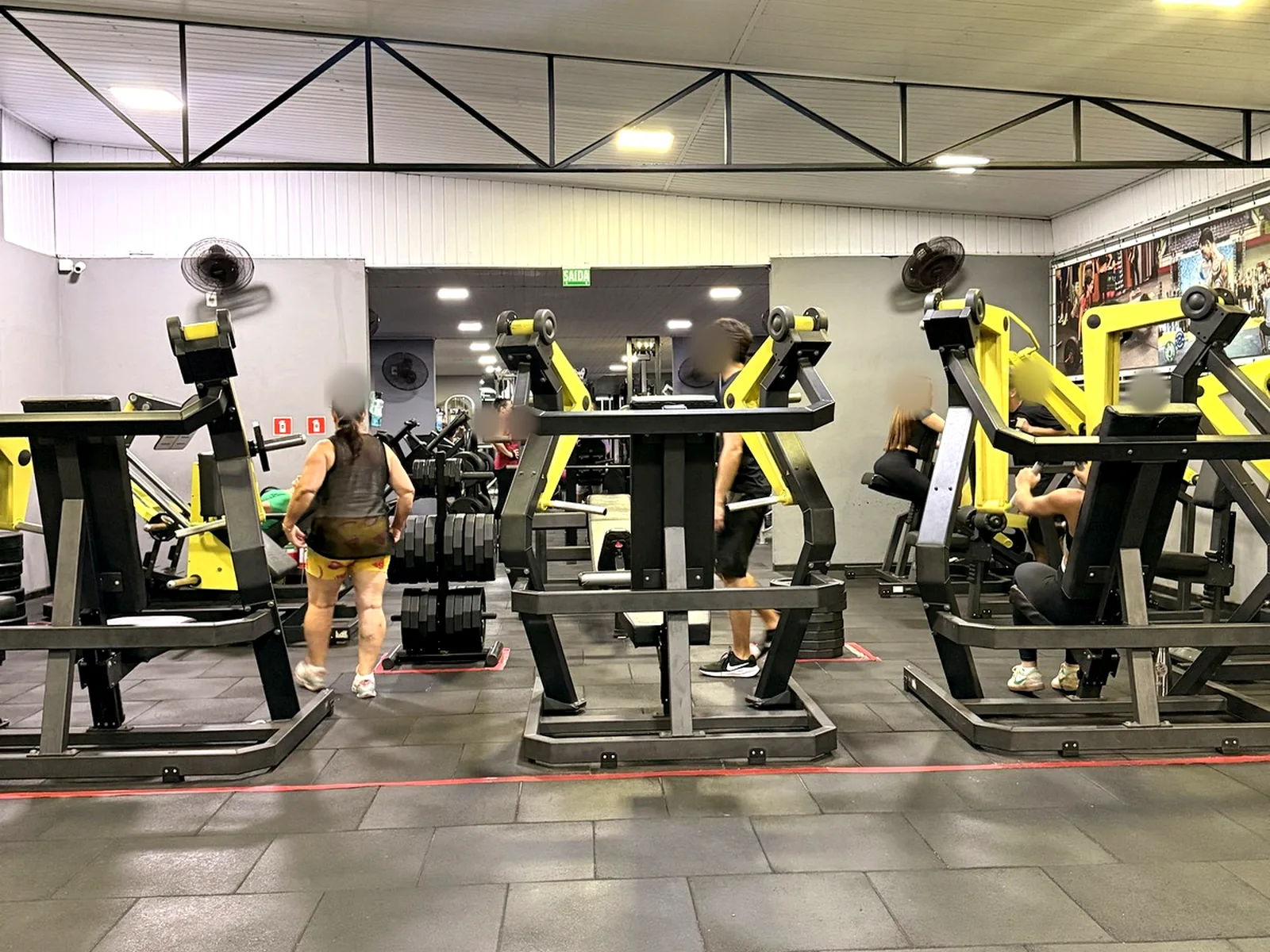 Salão da Academia Glória Fit com pé-direito alto, máquinas novas e área ampla de treino
