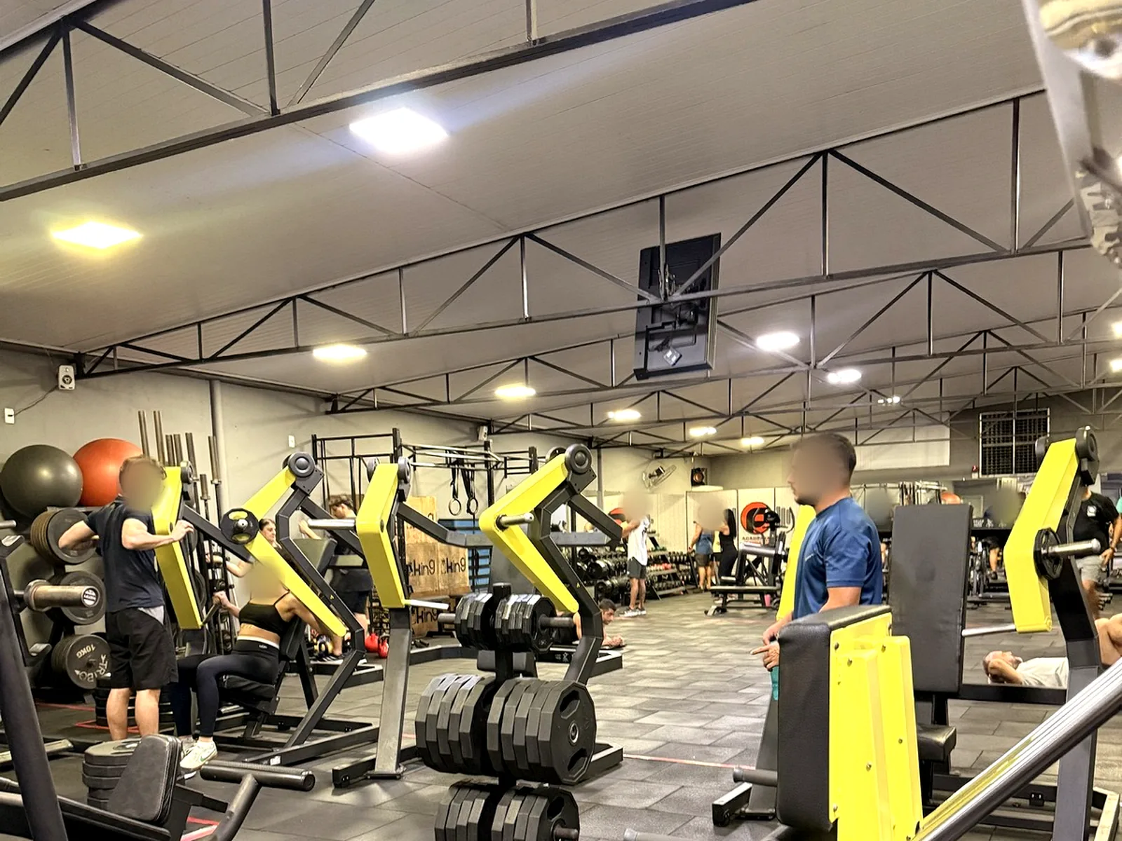 Máquinas de musculação e rack de anilhas no salão principal