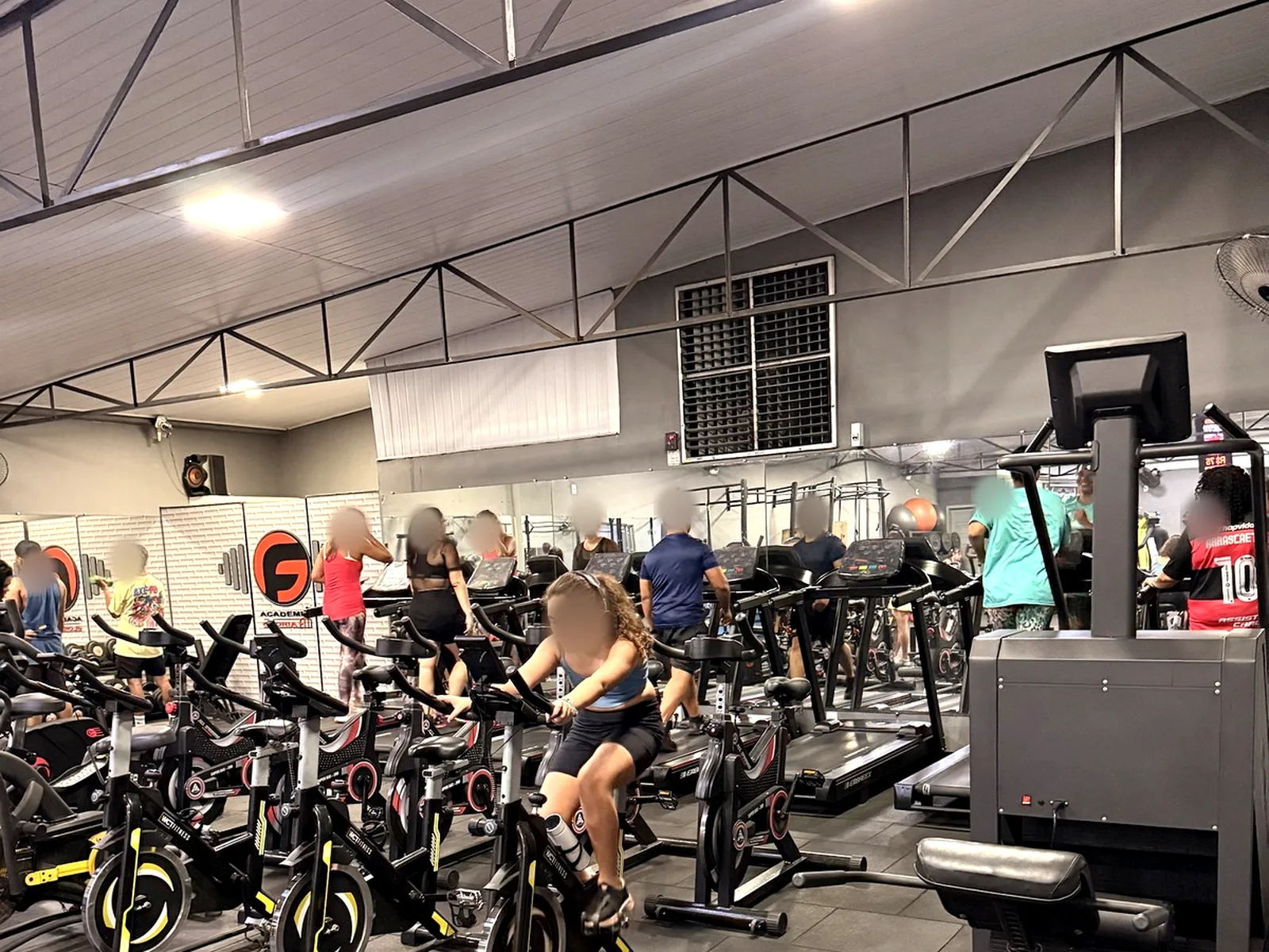 Área de spinning e cardio, com bikes e esteiras